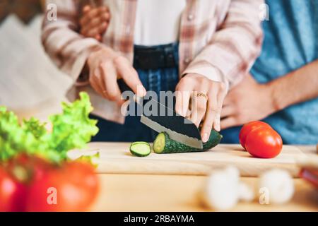 Female cooking healthy food cutting vegetable on kitchen. Close up photo of womans hands preparing salad Stock Photo