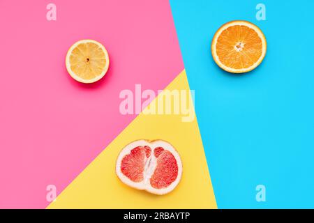 Citrus fruits on abstract geometry colored paper texture minimalism background with pastel pink, blue and yellow colors Stock Photo