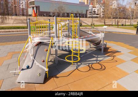 Children's playground, in Kiev, Ukraine, closed due to containment due to a coronavirus outbreak, covid-19. The games are wrapped in cellophane to Stock Photo