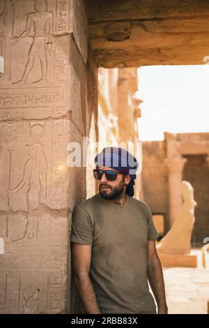 Portrait of a young man with a blue turban at the entrance to the Edfu Temple near the city of Aswan. Egypt, west bank of the nile in the city of Stock Photo