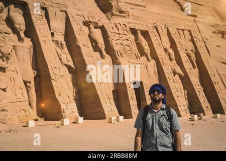 A young man wearing a blue turban visiting the Egyptian Temple of Nefertari near Abu Simbel in southern Egypt in Nubia next to Lake Nasser. Temple of Stock Photo