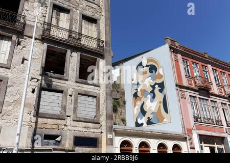 Mural with geometric shapes between houses in the historic old town, mural by Portuguese graffiti artist Hazul, Porto, Portugal Stock Photo