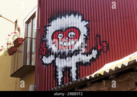 Scary figure with red face on red corrugated iron wall, graffiti, street art, Porto, Portugal Stock Photo