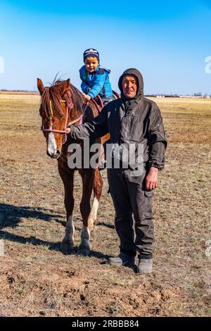 Kokpar player and his son, Kokpar, national horse game, Kazakhstan Stock Photo