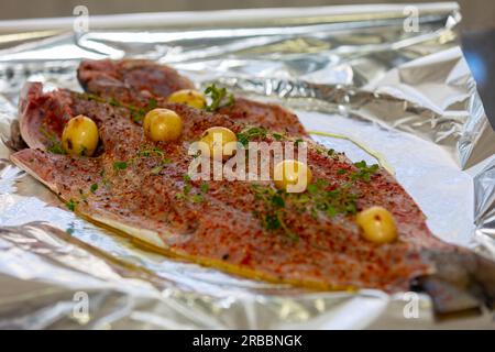 Traditional anchovy fish (Pomatomus saltador) seasoned ready to be baked in the oven Stock Photo