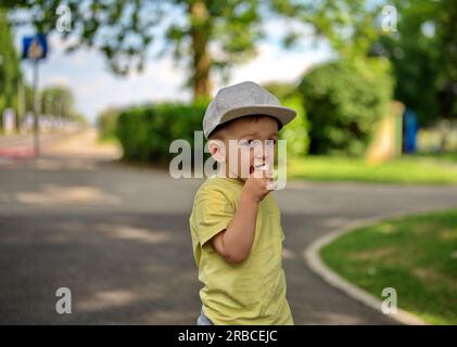 Portrait of little toddler in a park eating ice cream Stock Photo
