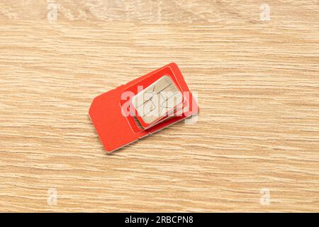 sim card of red color on an isolated background close-up Stock Photo