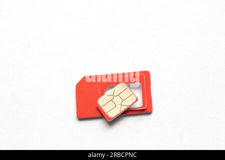 sim card of red color on an isolated background close-up Stock Photo