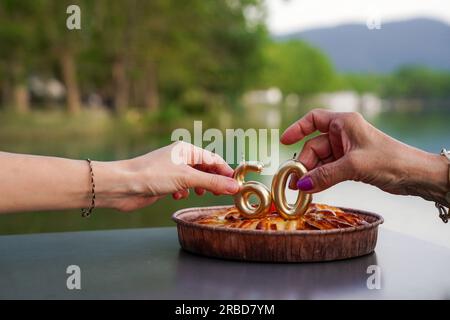 anniversary of 60 year old person with golden candles on a cake in the lake. birthday celebration of an old person Stock Photo
