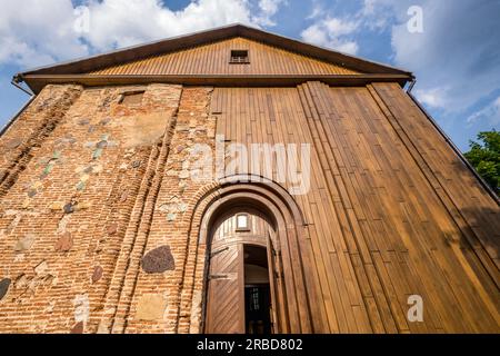 wall of an ancient orthodox church, monument of old brick russian architecture with texture of clay brick, decorated with inserts of colored stones in Stock Photo
