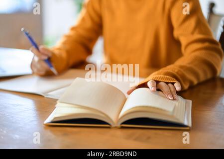 Asian woman's hand studying for qualifications Stock Photo