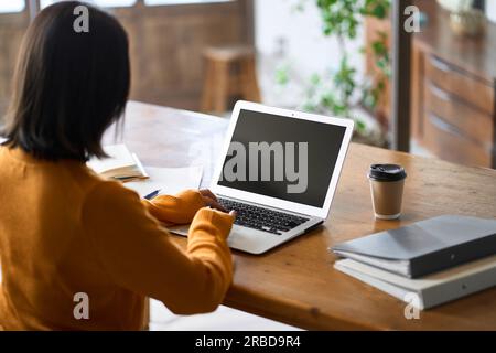 Back view of an Asian woman doing telework Stock Photo