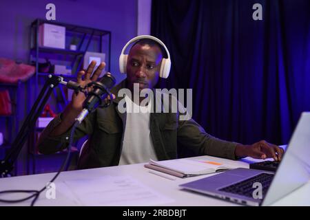 Serious blogger checking microphone before recording podcast Stock Photo