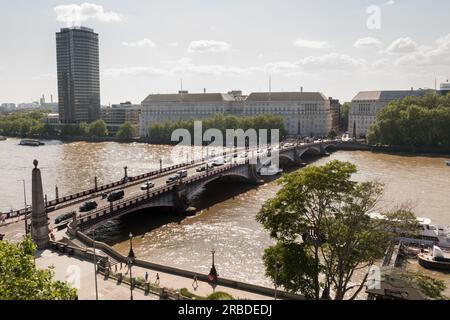 Southbound traffic passing across Lambeth Bridge with Thames House, Mi5 headquarters building on Millbank in the background, London, England, U.K. Stock Photo