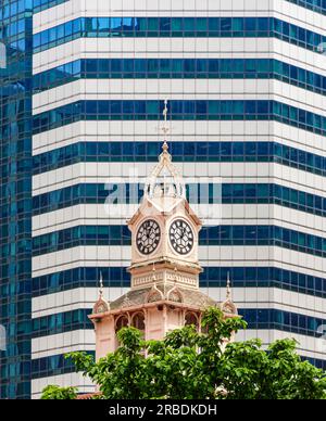 Old and new Singapore with the Lau Pa Sat clocktower against a modern office block behind Stock Photo