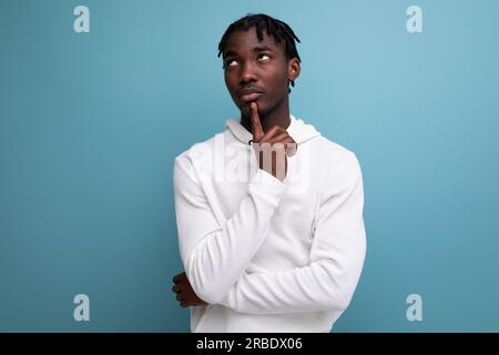 smart dark-skinned young brunette man solves a problem in his head Stock Photo
