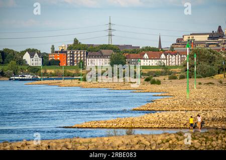 Cargo ship at low water on the Rhine near Duisburg-Homberg, view of Duisburg-Laar, houses on Deichstraße, gasometer of ArcelorMittal Hochfeld GmbH Sta Stock Photo