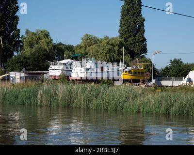 Kruibeke, Belgium, July 08, 2023, Several pleasure boats are lying on dry land along the side of the river Scheldt Stock Photo
