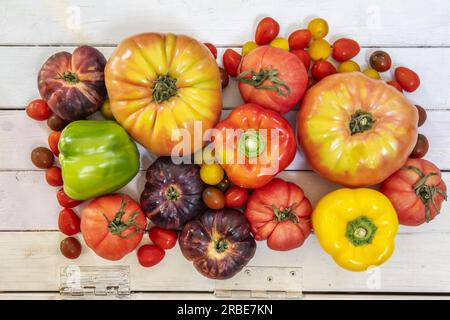 Still life seen from the top of all kinds of tomatoes , some peppers on a hinged wooden surface Stock Photo