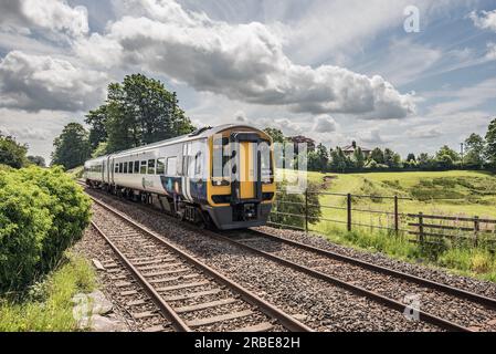 Express Sprinter number 158784 DMU, diesel hydraulic multiple unit two car set passing through Long Preston just before the Flying Scotsman passes. Stock Photo