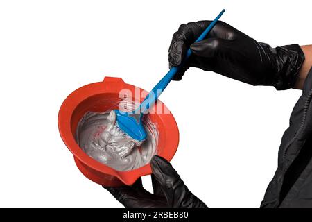 Hair coloring process mixing ingredients in a brush paint container dye on a white background isolated. Stock Photo