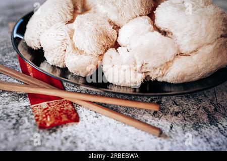 Hericium erinaceus or Lions mane mushroom with a Chinese chopsticks. Medical mushroom concept Stock Photo