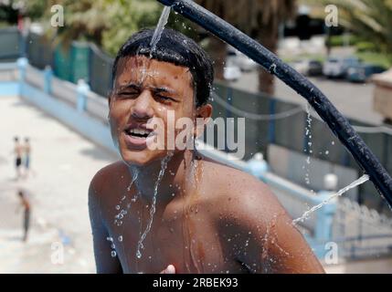 Sanaa. 9th July, 2023. A teenager uses tap water to cool himself around a public pool during a heatwave in Sanaa, Yemen on July 9, 2023. Credit: Mohammed Mohammed/Xinhua/Alamy Live News Stock Photo