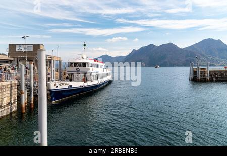 Intra-Verbania, Piedmont, Italy - April 9, 2023: Landscape of lake Maggiore with ferry boat at port of Intra Stock Photo