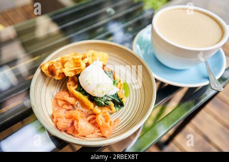 Potato waffles, Poached egg, avocado cream with salmon and egg . Healthy breakfast, protein. Restaurant dish.  Stock Photo