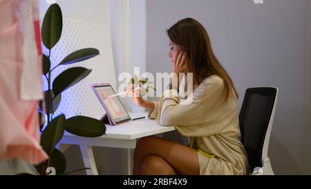 Happy female dressmaker working in workshop studio Stock Photo