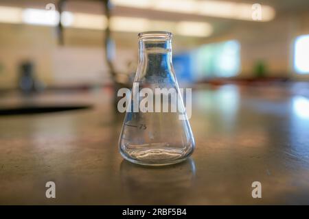 flask on a black resin table with a high school science room background. Stock Photo