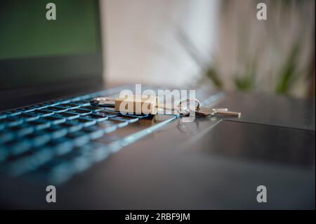 Low angle closeup view of a golden padlock with keys in it placed on laptop computer keyboard in a conceptual image of cyber security and online data Stock Photo