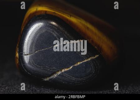 Tiger's eye is a variety of quartz containing inclusions of crocidolite, a mineral belonging to the asbestos group. The presence of these isooriented Stock Photo