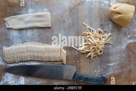 Process of making homemade pasta Cutting time on a wooden table. Stock Photo