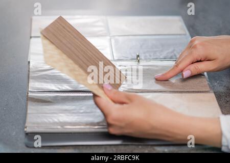 Catalog with samples of different types of wood. The process of selecting materials for home renovation, services of a designer or architect. Stock Photo