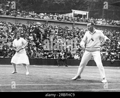 London, England:  1927 Americans Elizabeth Ryan and Frank Hunter playing against the British team in the Lawn Tennis Championships at Wimbledon. They won the mixed doubles championship. Stock Photo
