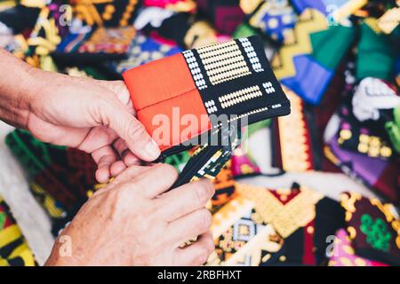 Hands holding purses with orange and black colors in focus. Selective focus. Closeup. Stock Photo