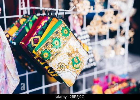 Closeup of multi-colored patterned purses on a rack of product display. Selective focus. Stock Photo