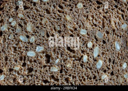 Abstract background or texture homemade black bread with sunflower seeds, close up, top view, macro Stock Photo