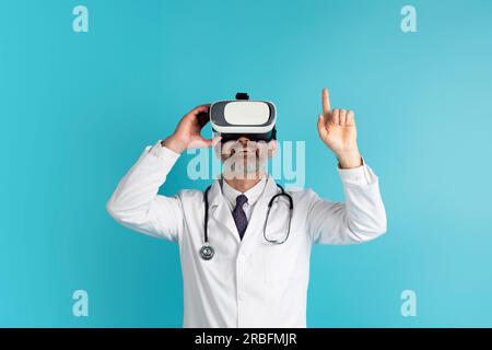 Doctor medical worker using virtual reality headset, blue background Stock Photo