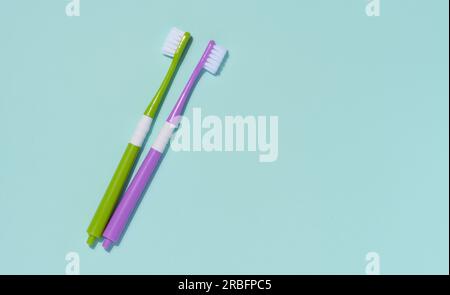 Two plastic toothbrushes on a blue background, oral hygiene. Stock Photo