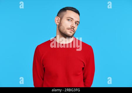 Shy confused man portrait on blue background. Emotions concept Stock Photo