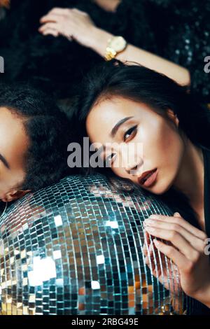 Pretty woman relax and lying down on the floor on disco ball in nightclub after crazy party. New year, Birthday, Holiday Event, Fun concept Stock Photo