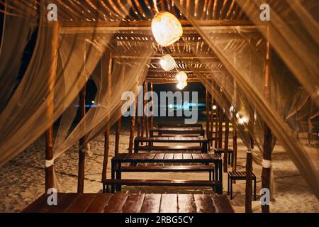 Empty beach restaurant lounge bar with lantern in the evening on tropical island. Summer vacation, romantic dinner concept Stock Photo