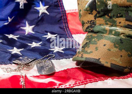 Military cover on an American Flag with dog tags Stock Photo