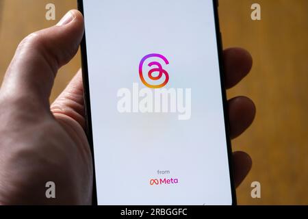 Man's hand holding a smartphone showing the Instagram Threads app by Meta on a white background with copy space. UK Stock Photo
