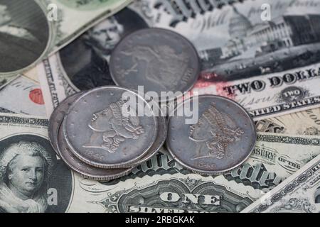 Old west US banknotes and silver certificates with silver dollar coins background Stock Photo