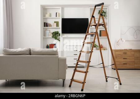 Wooden folding ladder in stylish living room Stock Photo