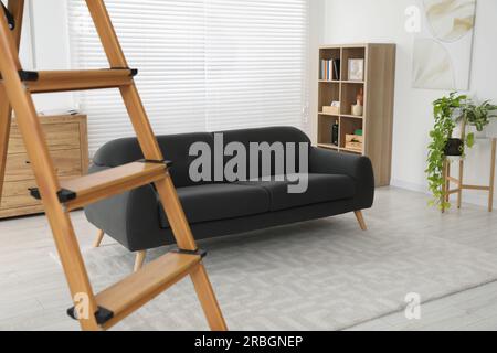 Wooden folding ladder in stylish living room Stock Photo