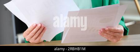 Woman holding financial documents with charts and graphs Stock Photo